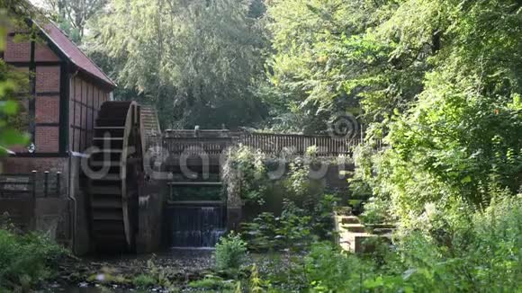 在黑德修道院的废墟上有一条小溪有一个水轮和一座桥视频的预览图