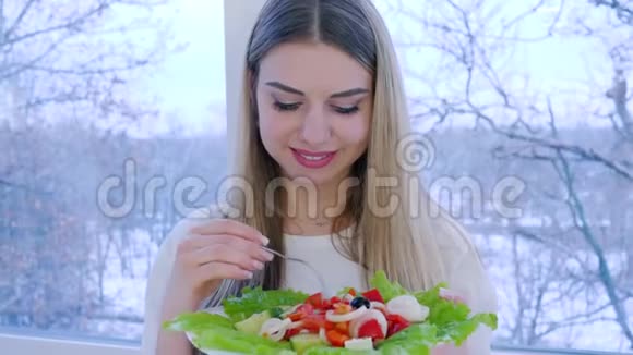 健康的午餐微笑的女性在窗口的背景下吃有用的食物视频的预览图