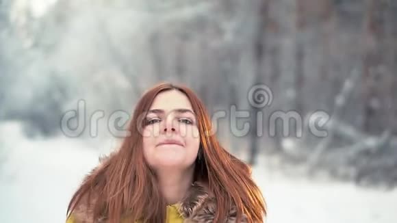 一个年轻的女孩喜欢在白雪覆盖的森林里散步视频的预览图