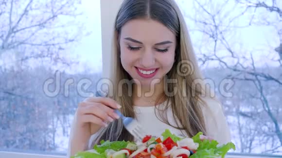 背景窗上有一盘新鲜蔬菜沙拉的健康女性画像视频的预览图