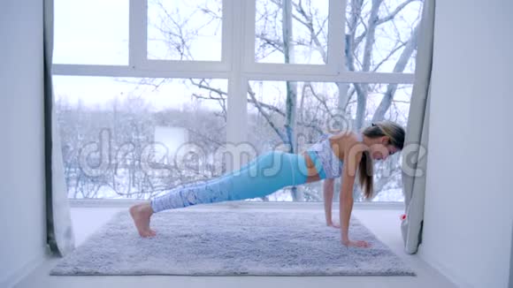 瑜伽课苗条的女性下午在大全景窗附近的房间做体操视频的预览图
