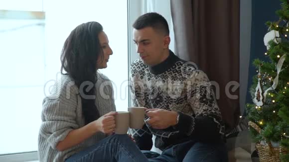 一对夫妇在圣诞树附近喝茶视频的预览图