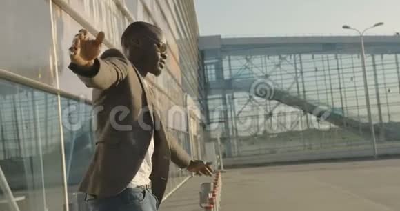 穿着摩登服装的非洲男人哈伯多姆站在杆子上3他站在原地踏步试图保持身体的平衡视频的预览图