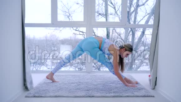 体操灵活的女人在健身俱乐部的全景窗口伸展视频的预览图