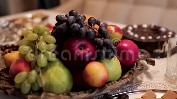 靠近传统的桌子有苹果葡萄梨和不同的东方糖果有坚果食物和视频的预览图