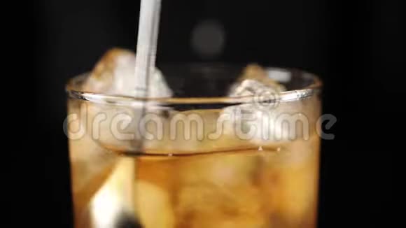 老式鸡尾酒调酒师用调酒师的勺子把糖安格斯图拉冰块和波旁威士忌混合在岩石玻璃中玻璃视频的预览图