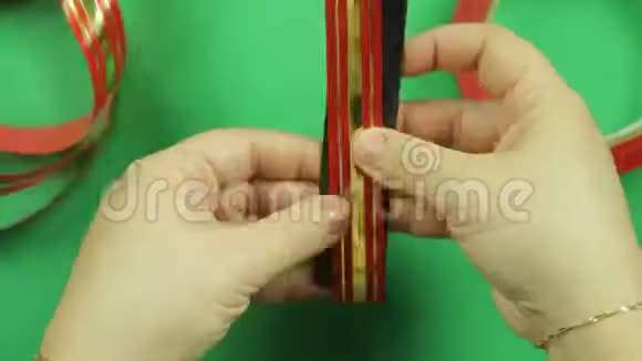 在绿色背景上做一个红色丝带的礼物蝴蝶结时间跨度视频的预览图