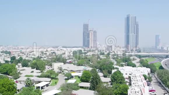 从上面看到迪拜有摩天大楼小房子道路和树木库存为现代城市提供空中服务视频的预览图