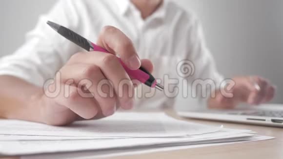 关闭疲惫的商人工作与笔记本电脑一个人紧张地用钢笔做动作工作中有问题视频的预览图
