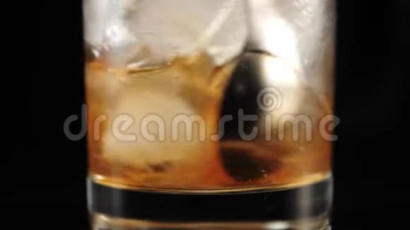 老式鸡尾酒调酒师用调酒师的勺子把糖糖冰块和波旁威士忌混合在玻璃杯中视频的预览图
