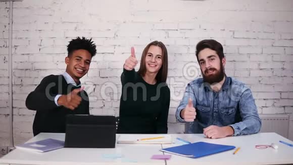 多民族的商业团队在现代办公室里坐在桌子旁竖起大拇指慢镜头视频的预览图