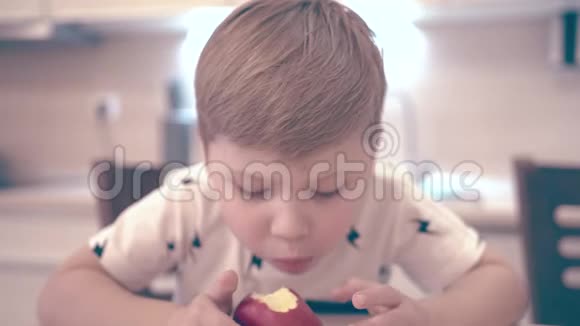 小男孩坐在厨房吃苹果视频的预览图