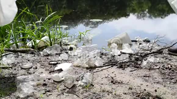 志愿者在河边清理垃圾女人在湖里捡起一瓶塑料环境污染视频的预览图