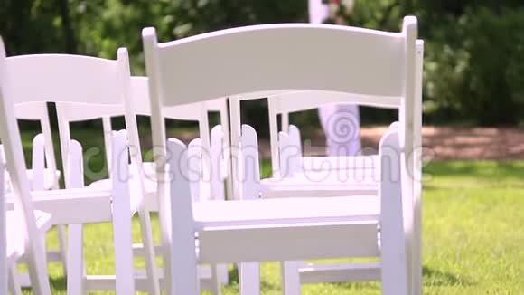 潘在户外婚礼上坐着白色椅子背景中有花的阿尔布尔视频的预览图