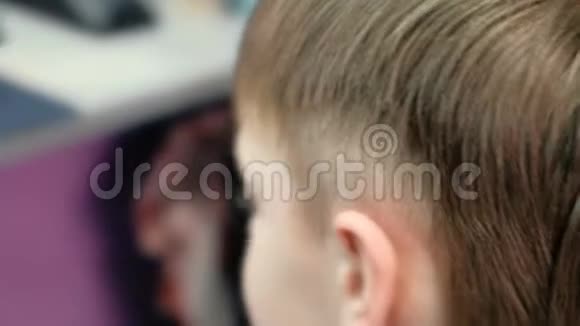 理发师用剪刀剪男孩头发无法辨认的男孩视频的预览图