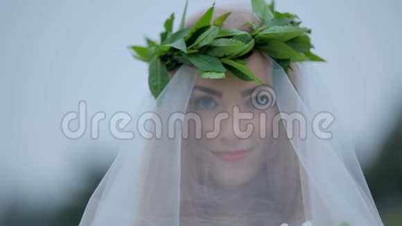 戴着面纱的美丽新娘戴着一束鲜花神秘的形象视频的预览图