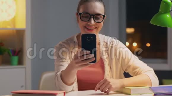 晚上坐在办公桌前戴眼镜的女人视频的预览图