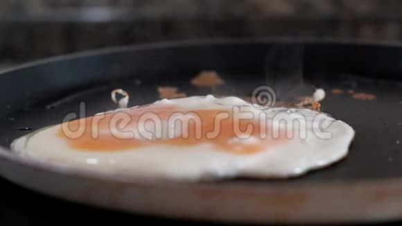 煎锅里翻一个鸡蛋的特写镜头视频的预览图