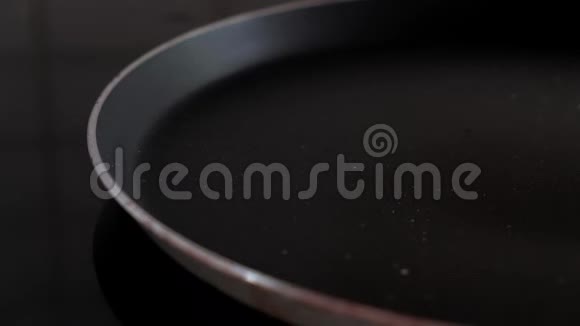 煎锅中打碎一个鸡蛋的特写镜头视频的预览图