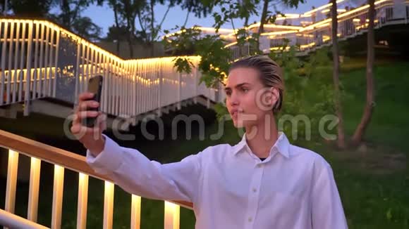 现代女性站在梯子上晚上在智能手机上自拍交流理念视频的预览图