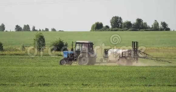 用喷雾机在田间喷洒农药或化学品的肥料拖拉机视频的预览图