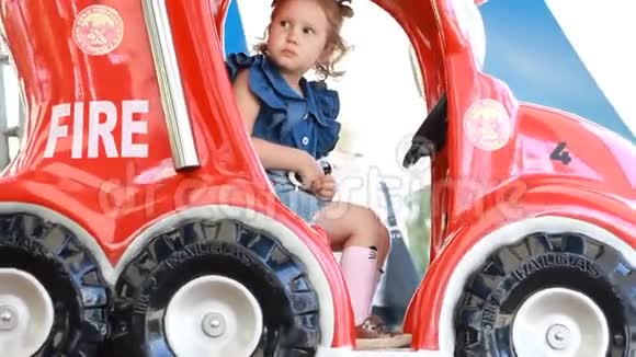 小女孩在公园里骑着消防车娱乐儿童景点视频的预览图