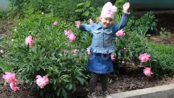 快乐的女孩在花园里和牡丹跳舞视频的预览图