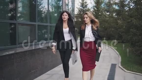 商务人员靠近办公中心两个穿西装的年轻女人女人看着钟视频的预览图