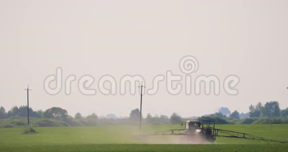 用喷雾机在田间喷洒农药或化学品的肥料拖拉机视频的预览图