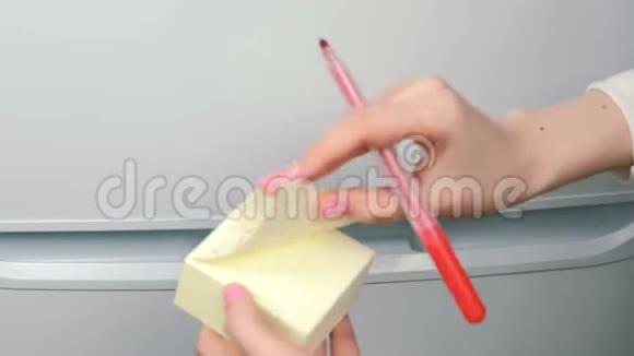 特写女人她的手贴着黄色的贴纸纸上面写着不在冰箱上吃我的食物视频的预览图