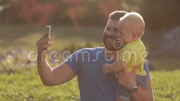 微笑的父子在公园自拍视频的预览图
