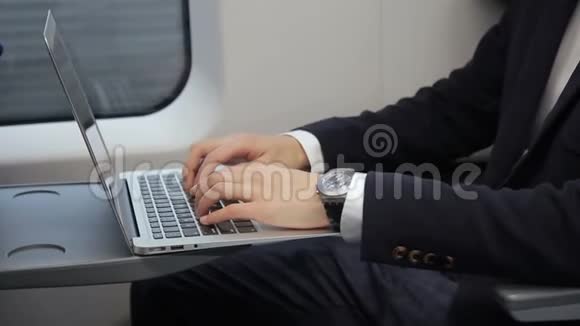 男性手在火车上用笔记本电脑键盘打字特写视频的预览图