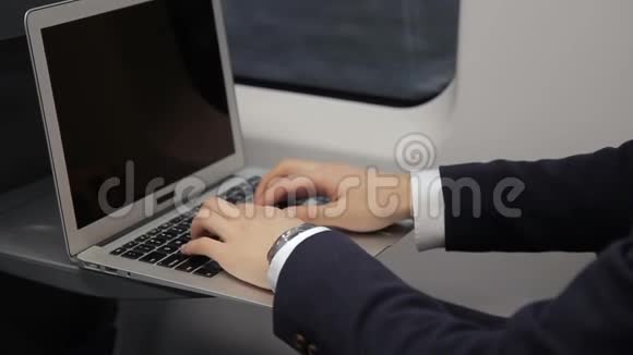 年轻商人的手他在火车上旅行时用笔记本电脑键盘打字视频的预览图