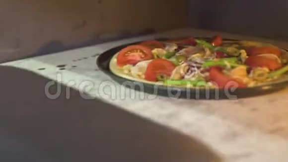 生披萨与奶酪西红柿和意大利辣香肠在热烤箱比萨饼厨房传统披萨烘焙视频的预览图