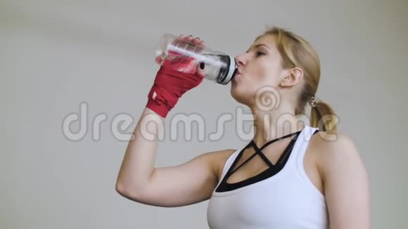 嗜血的女拳击手在经过严格的训练后从瓶子里喝冷水视频的预览图