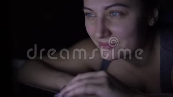 迷人的快乐女人在晚上躺在床上在笔记本电脑键盘上打字4K视频的预览图