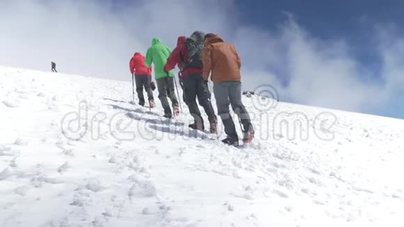 登山者登上雪坡的山顶在晴朗的天气里高加索山脉慢运动视频的预览图