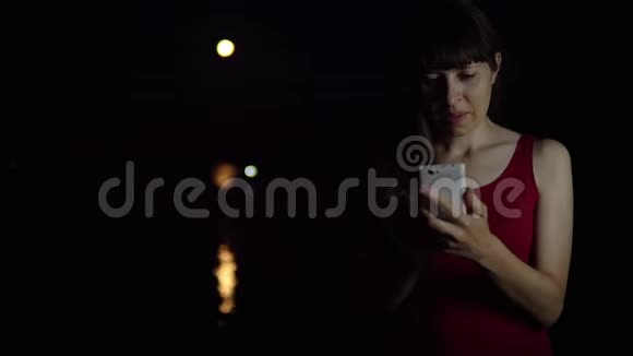 一个年轻的女人在河边拍红月亮视频的预览图