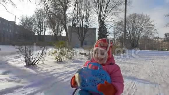 女孩骑着雪橇穿过雪地视频的预览图