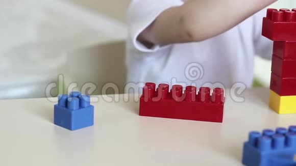 幼儿的特写他的手在桌子上用彩色积木玩儿童发展视频的预览图