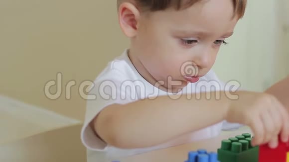 一个小男孩在桌子上玩彩色积木的特写3那男孩把设计师的手收视频的预览图