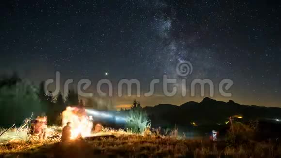 在银河系的星光夜里朋友们坐在篝火旁视频的预览图