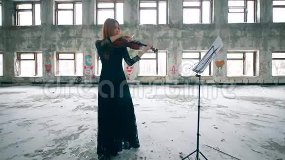 破旧的大楼里有一个女人拉小提琴视频的预览图
