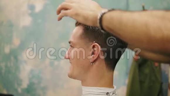 理发店里一位时尚的男性顾客的头发上涂蜡理发师的手的特写镜头视频的预览图