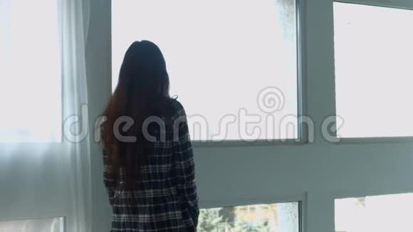 性感梦想的女人看着窗外视频的预览图