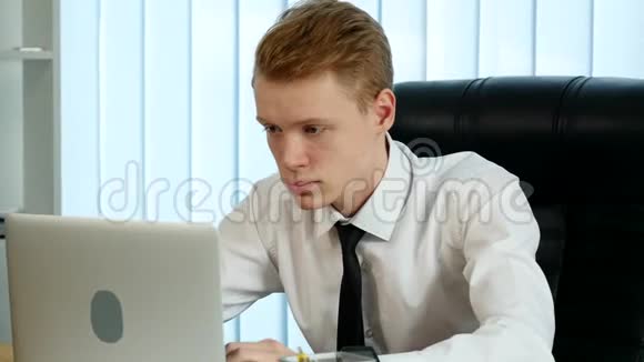 一个人从玻璃上喝水在笔记本电脑上工作视频的预览图