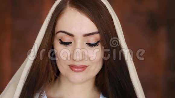 一位戴头巾名叫头巾的年轻神秘阿拉伯女人的特写镜头微笑着看着镜头视频的预览图