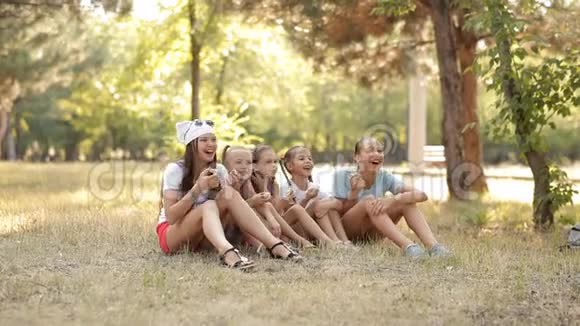 孩子们在大自然的草坪上玩得开心交流笑吃苹果视频的预览图