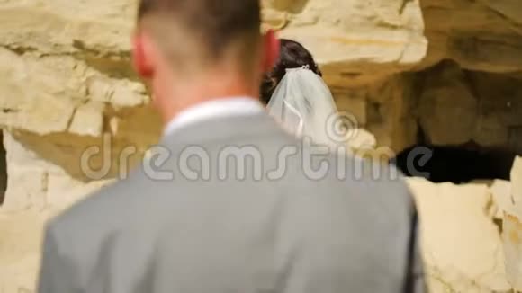 幸福的夫妻在高高的砂岩峭壁上散步视频的预览图