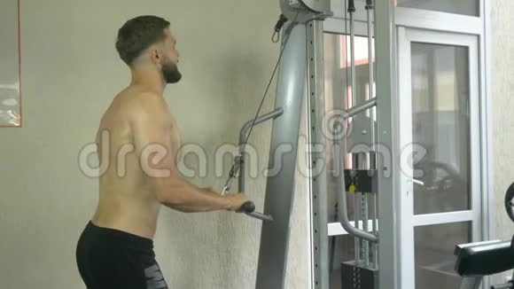 一个身材赤裸的年轻人在健身房锻炼锻炼手部肌肉视频的预览图